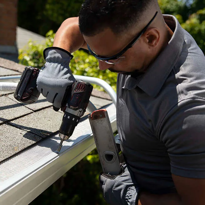 Installer drilling gutter guard roof edge, Seminole County FL